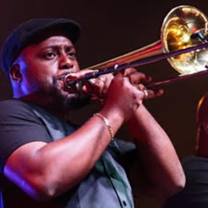 Performer Derrick Harris playing the trombone on stage
